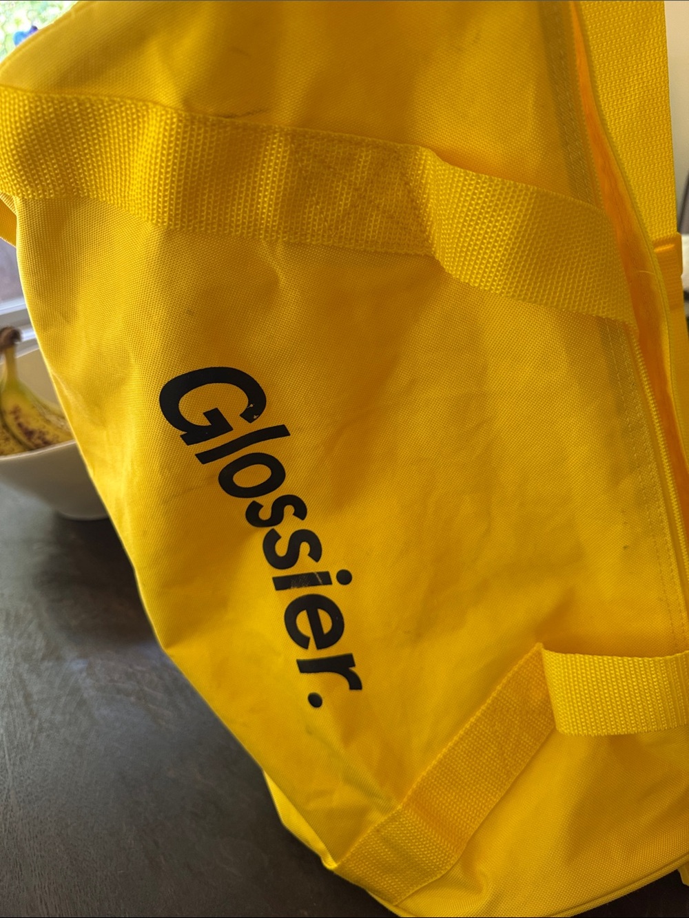 Glossier yellow duffle bag.